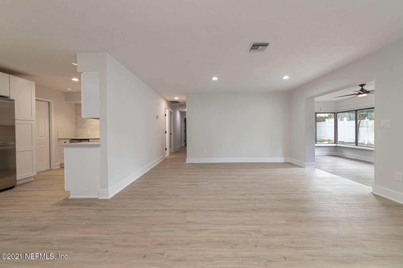 108 Linden Road St. Augustine, FL 32086 - Photo 4 of 36 a view of an empty room with wooden floor and a kitchen