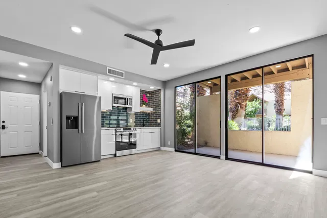 a view of a kitchen with refrigerator and wooden floor