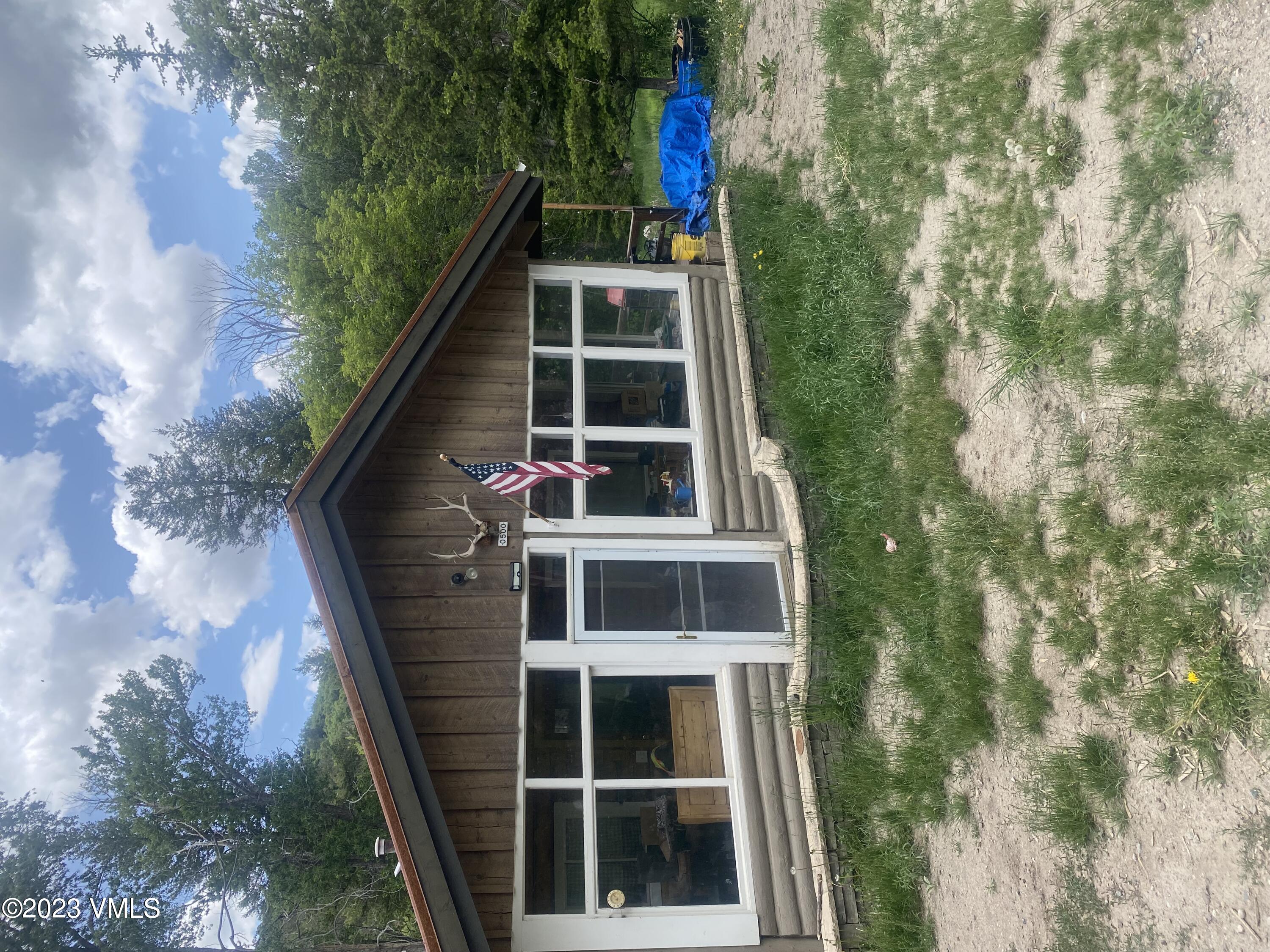 500 Sweetwater Road Gypsum, CO 81637 - Photo 1 of 10 a view of a house with a large window and a yard with wooden fence