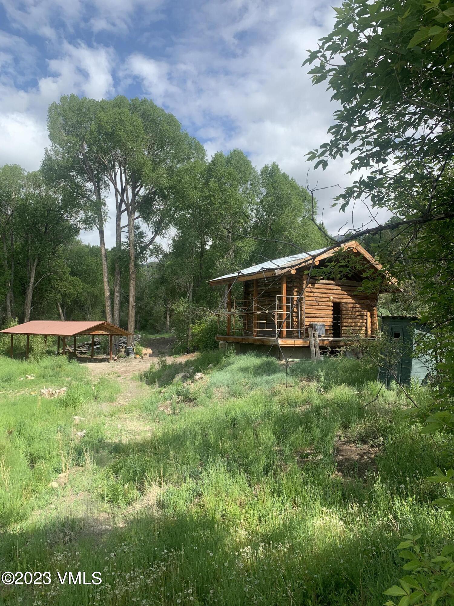 500 Sweetwater Road Gypsum, CO 81637 - Photo 7 of 10 a backyard of a house with plants and large trees
