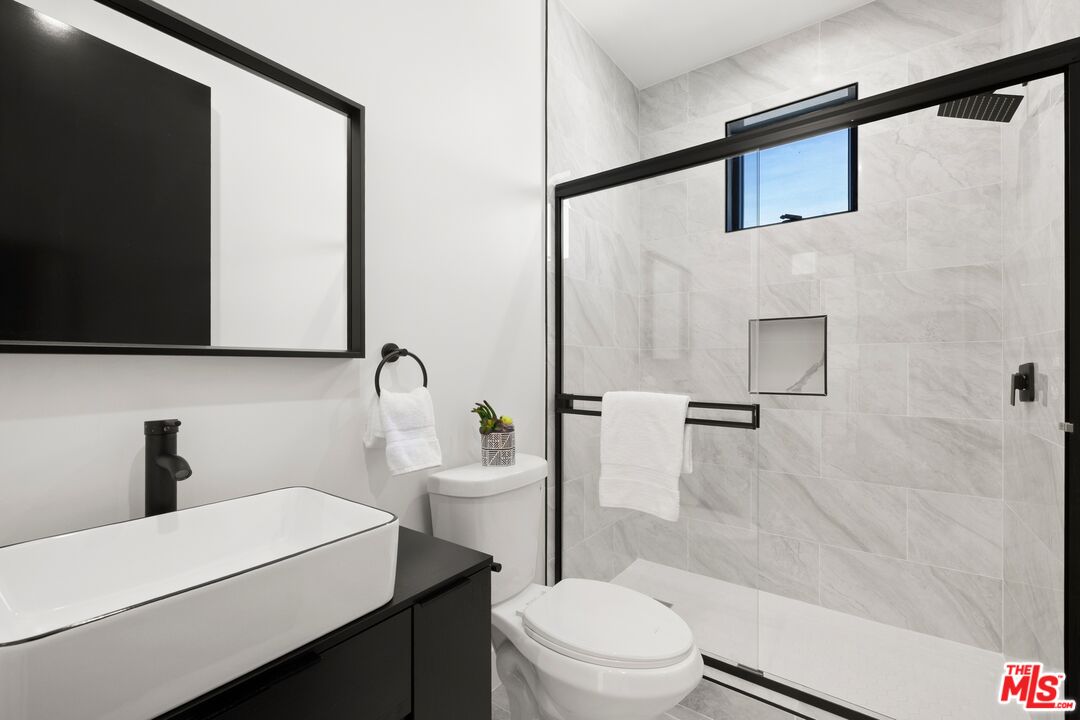 5012 Enfield Avenue Encino, CA 91316 - Photo 28 of 36 a bathroom with a toilet a sink and shower