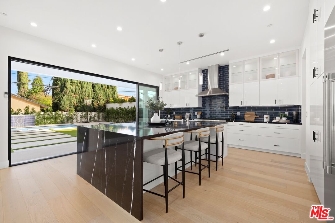 5012 Enfield Avenue Encino, CA 91316 - Photo 10 of 36 a kitchen with stainless steel appliances kitchen island granite countertop a stove a sink and a refrigerator