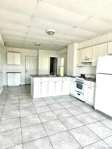 a large white kitchen with a stove a sink dishwasher and a refrigerator