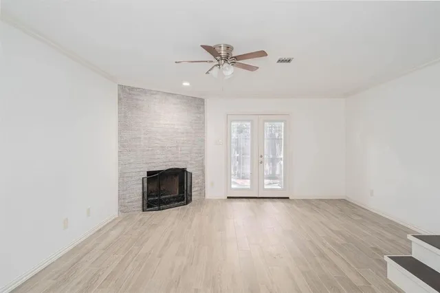 wooden floor fireplace and windows in an empty room