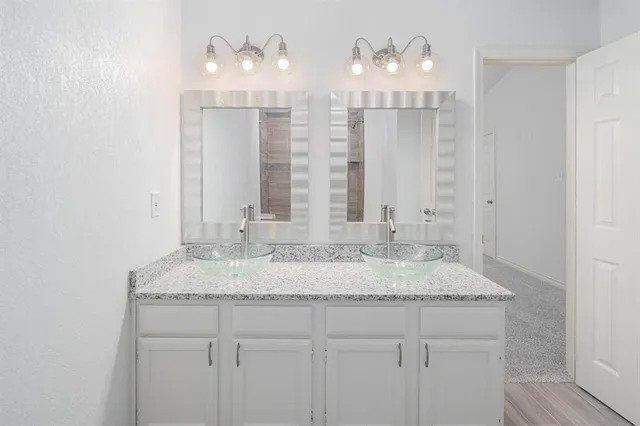 a bathroom with double sink and a mirror