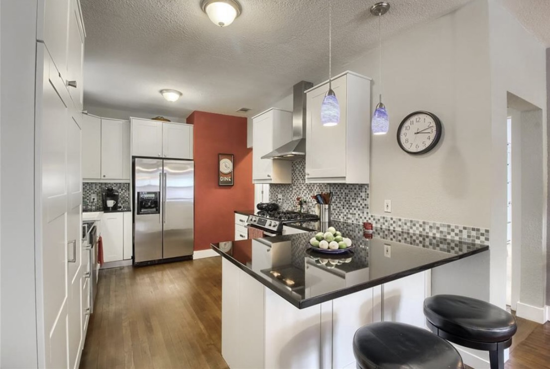 702 West N Loop Boulevard Austin, TX 78751 - Photo 9 of 23 Culinary aspirations find their home in this well-appointed kitchen featuring a functional island.