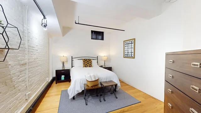 a bedroom with a bed and wooden floor