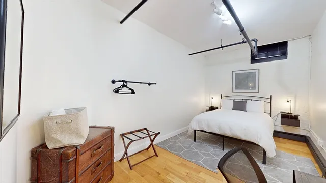 a bedroom with a bed and wooden floor