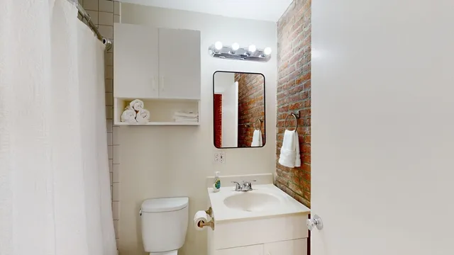 a bathroom with a toilet sink and mirror