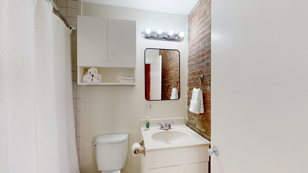 19 Stanhope Street, Unit 1C Boston, MA 02116 - Photo 19 of 19 a bathroom with a toilet sink and mirror