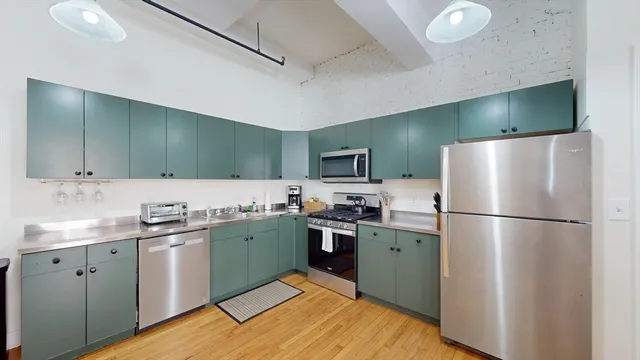 a kitchen with a sink a refrigerator and cabinets