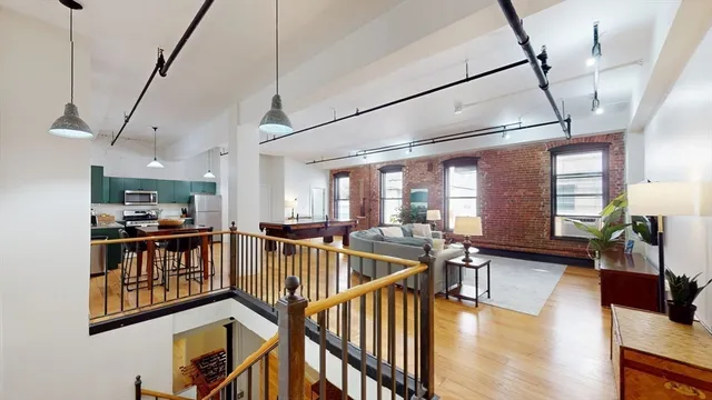 a view of a livingroom with furniture wooden floor and windows