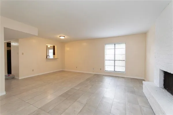 an empty room with windows and fireplace