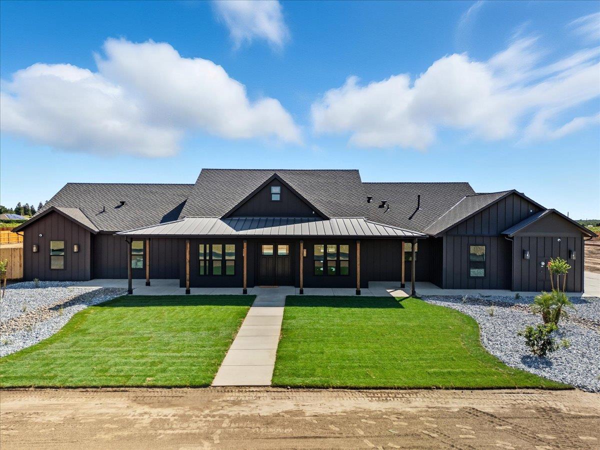 a view of a big house with a big yard and large trees