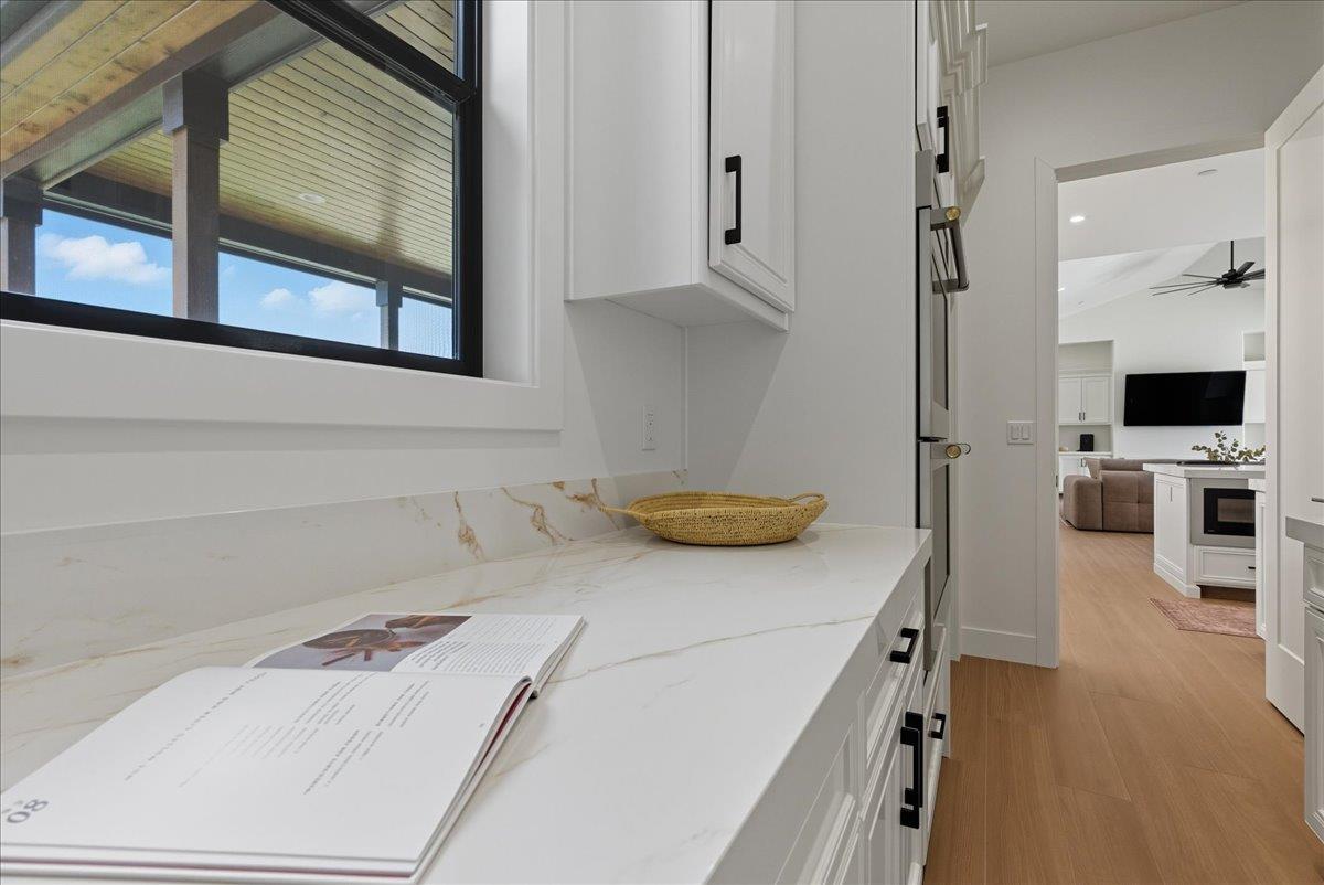 605 South Anderson Road Exeter, CA 93221 - Photo 27 of 81 a kitchen with a white cabinets and wooden floor