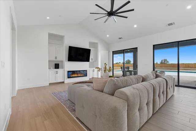 an empty room with a window and a fan
