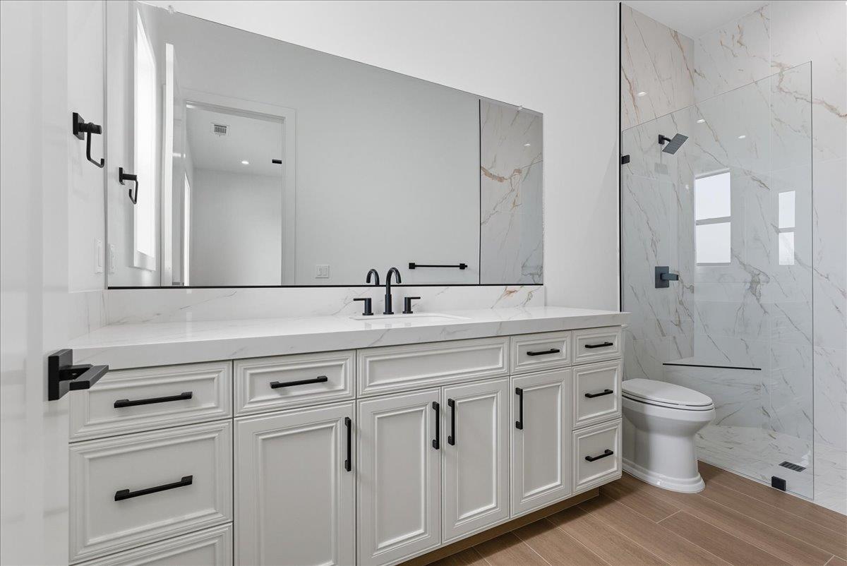 605 South Anderson Road Exeter, CA 93221 - Photo 43 of 81 a bathroom with a double vanity sink a toilet and a shower