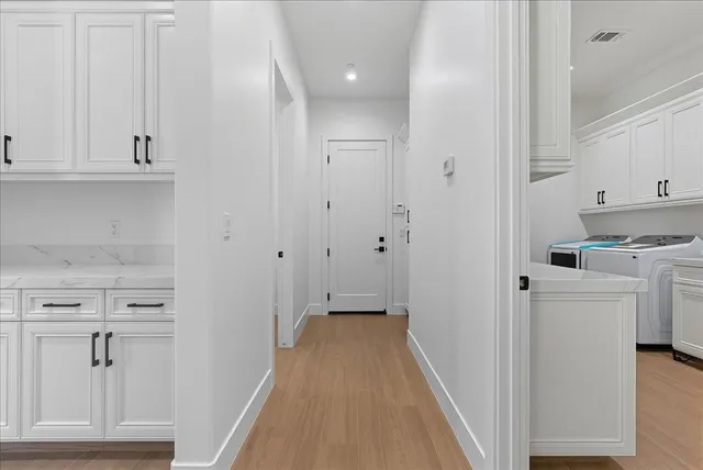 an empty room with wooden floor cabinet and windows