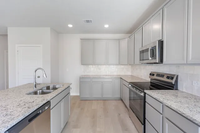 a kitchen with a sink stove and cabinets