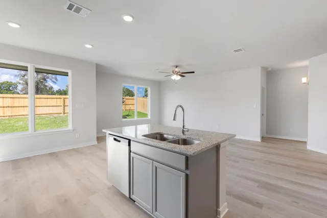 a kitchen that has a sink and a stove top oven