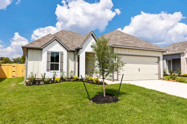 a front view of a house with a yard and trees