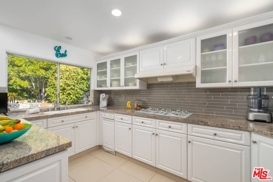 3104 Hutton Drive Beverly Hills, CA 90210 - Photo 10 of 37 a kitchen with granite countertop white cabinets and white appliances