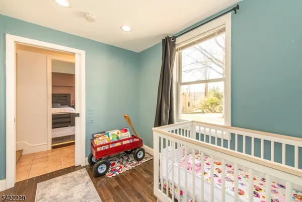 a living room with baby crib furniture and a window