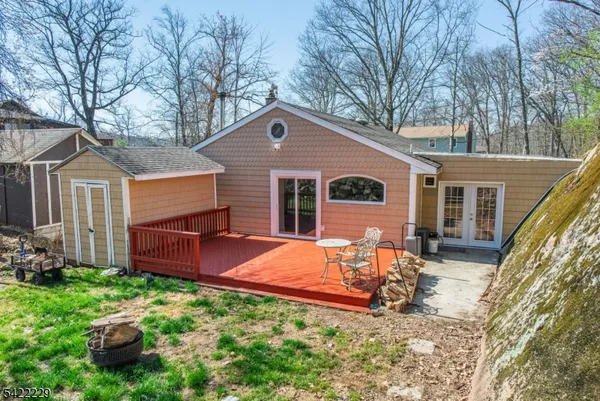 a view of backyard of house with wooden fence and large trees