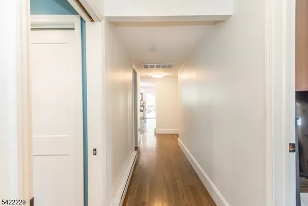 a view of a hallway with wooden floor