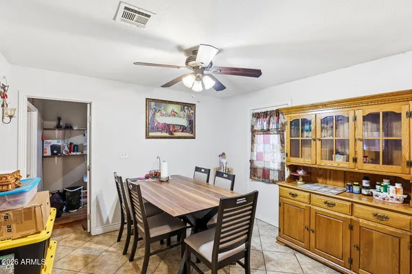 a kitchen with stainless steel appliances kitchen island granite countertop a refrigerator a stove a sink a dining table and chairs with wooden floor