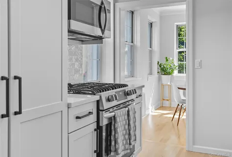 a kitchen with a stove and a white wooden cabinets