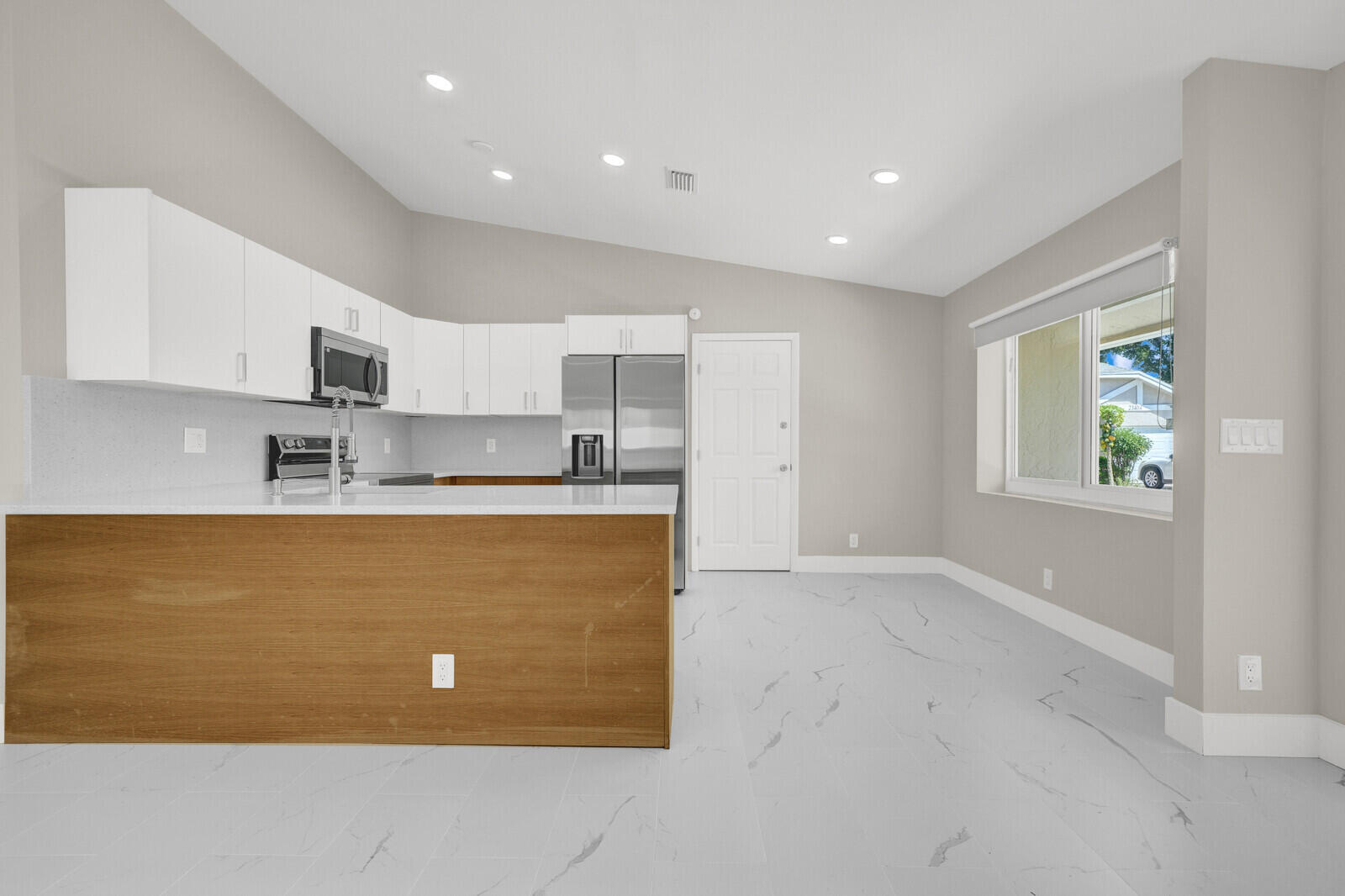 23392 East Country Club Drive East Boca Raton, FL 33428 - Photo 5 of 21 a view of kitchen with kitchen island a sink wooden floor and counter top space
