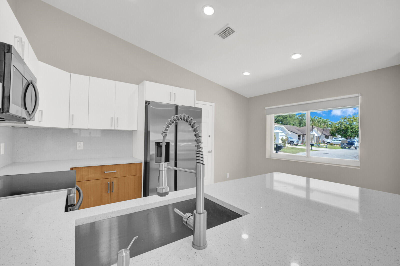 23392 East Country Club Drive East Boca Raton, FL 33428 - Photo 6 of 21 a kitchen with stainless steel appliances a refrigerator and a stove top oven