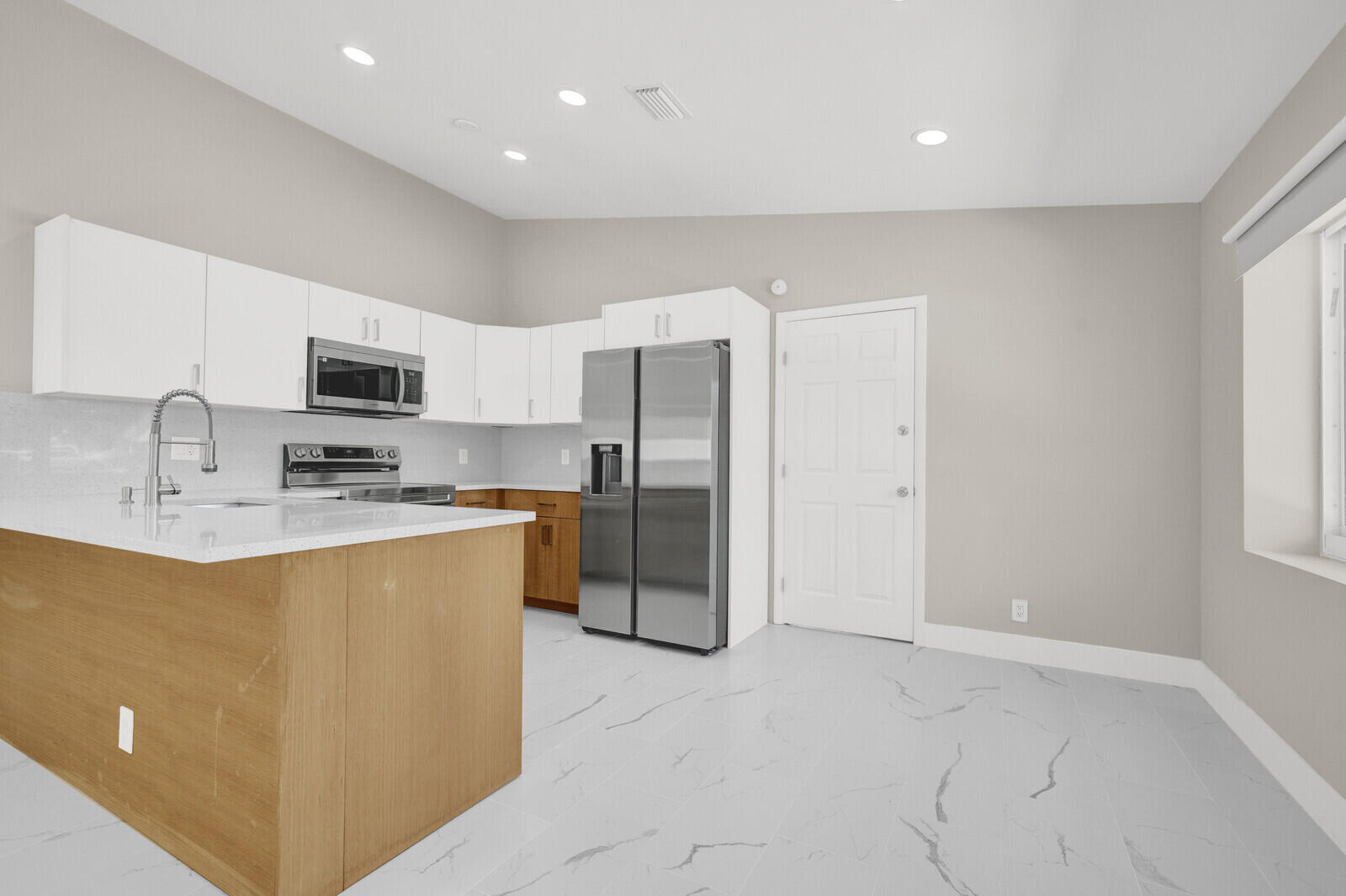 23392 East Country Club Drive East Boca Raton, FL 33428 - Photo 7 of 21 a kitchen with stainless steel appliances granite countertop a refrigerator a sink a stove a microwave a counter top and oven