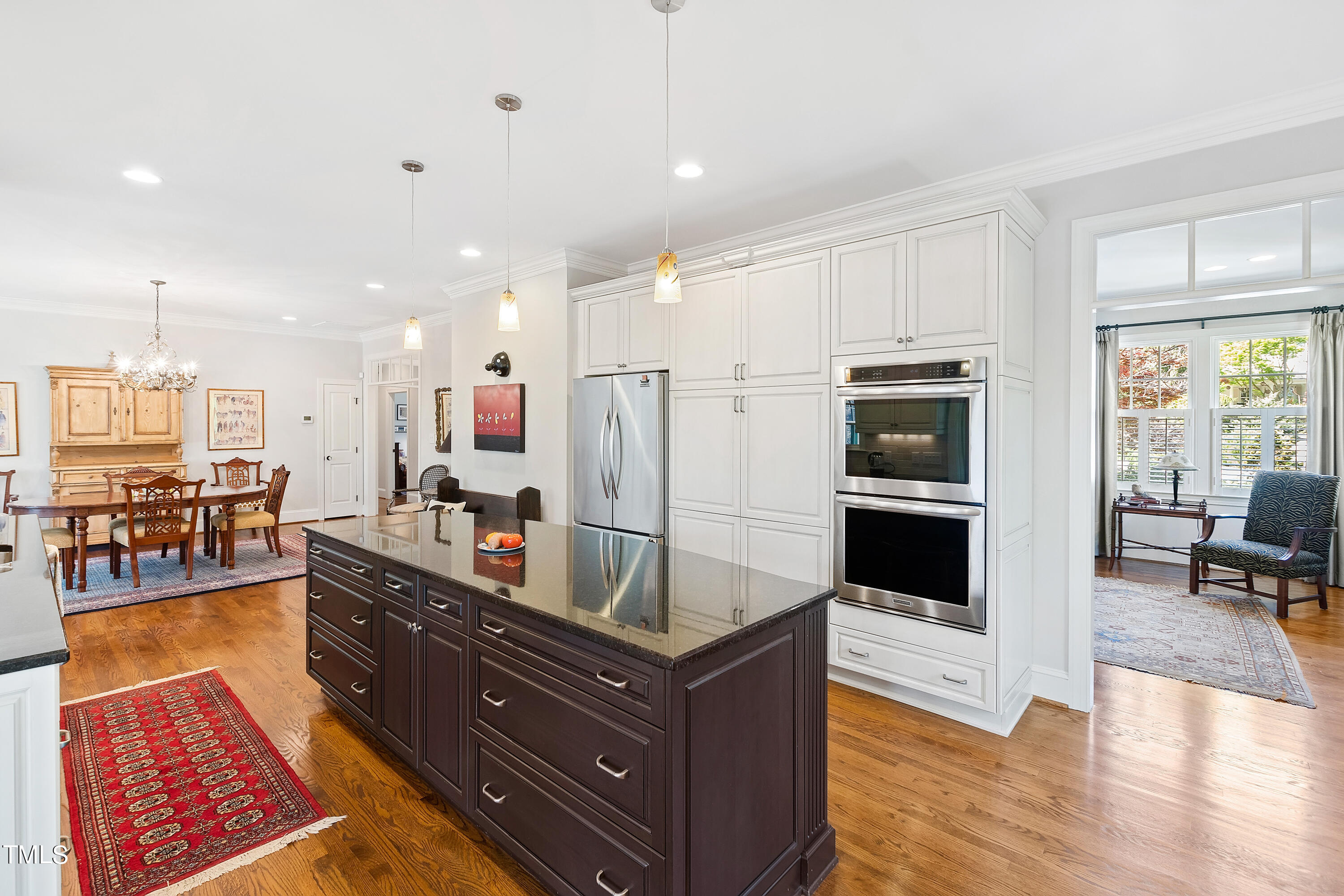 2210 Coley Forest Place Raleigh, NC 27607 - Photo 20 of 44 a living room with stainless steel appliances kitchen island granite countertop a table chairs and a view of living room