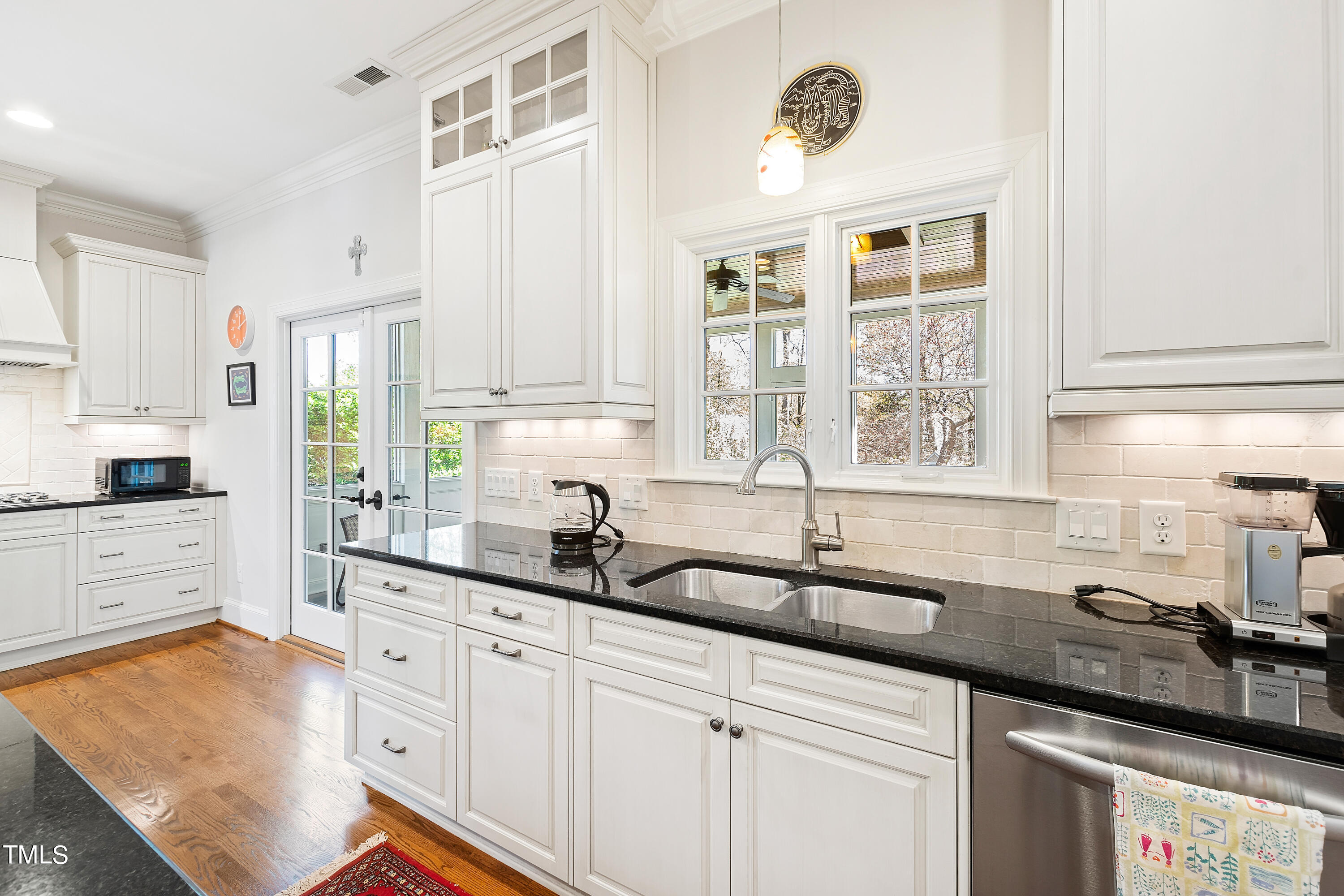 2210 Coley Forest Place Raleigh, NC 27607 - Photo 22 of 44 a kitchen with granite countertop a sink stainless steel appliances white cabinets and a window