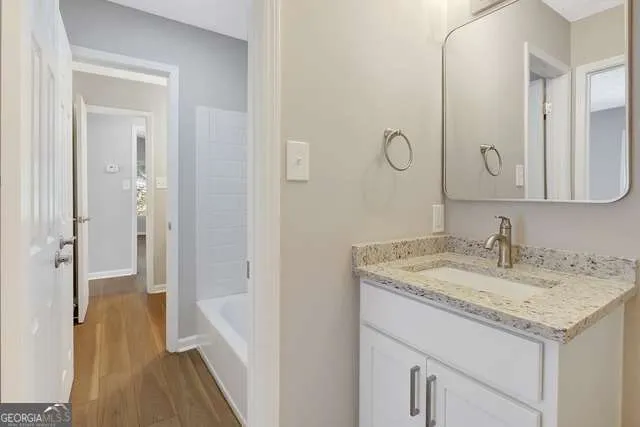 a bathroom with a granite countertop sink and a mirror