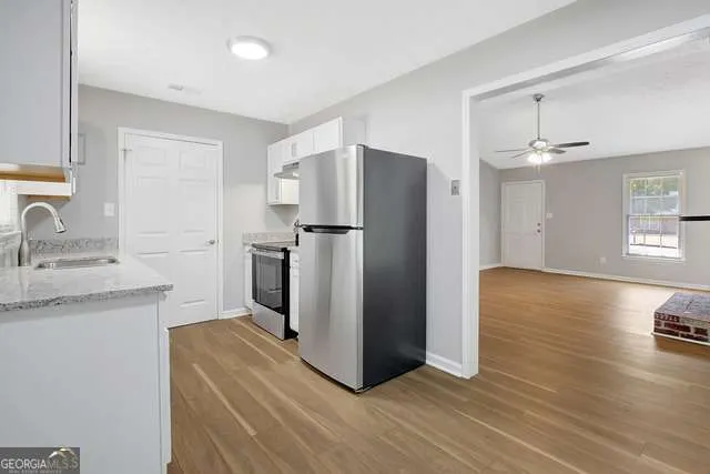 a kitchen with a refrigerator sink and wooden floor