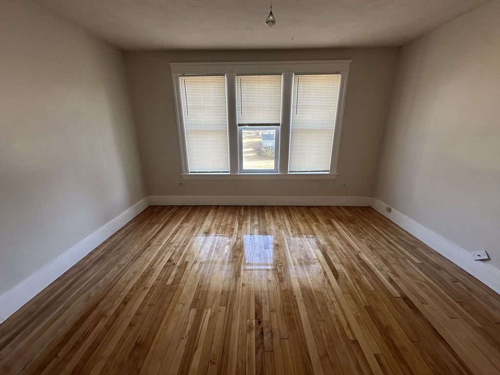 242 Greenwood Street Worcester, MA 01607 - Photo 4 of 10 wooden floor in an empty room with a window