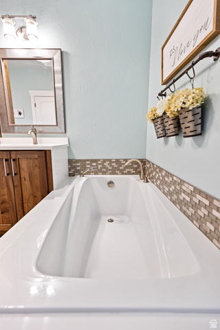 580 Cherry Ridge Lane Richmond, UT 84333 - Photo 21 of 53 Bathroom featuring vanity, a garden tub, and a textured wall