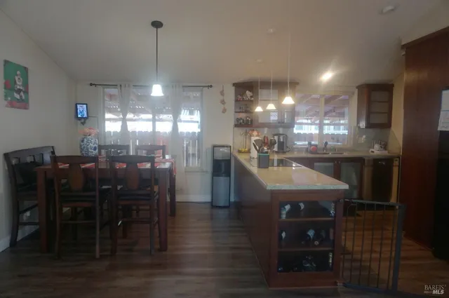 a kitchen with stainless steel appliances kitchen island granite countertop a table chairs and a chandelier