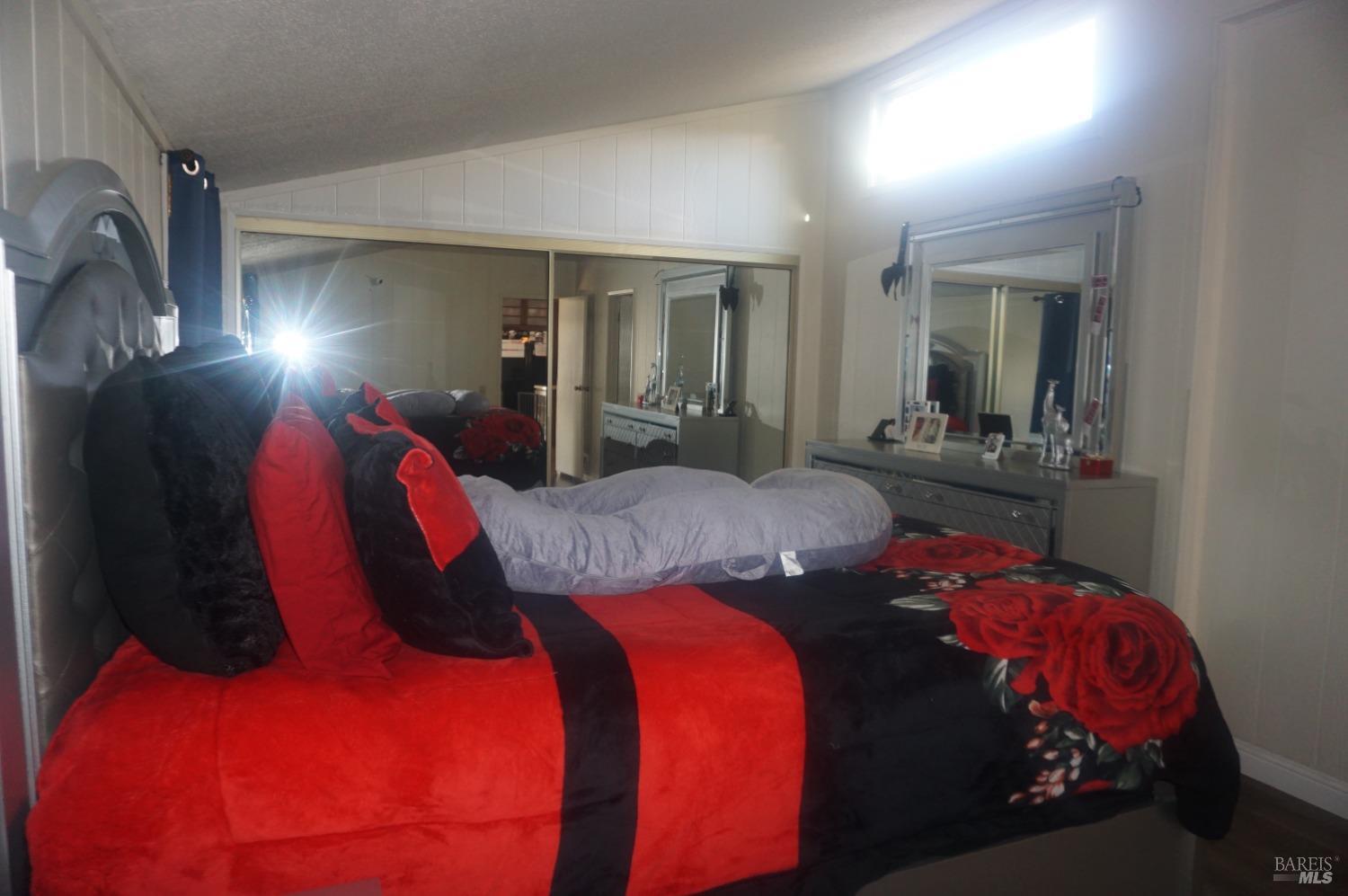 6004 Monticello Road, Unit 10 Napa, CA 94558 - Photo 33 of 41 a bedroom with a bed and closet with mirror