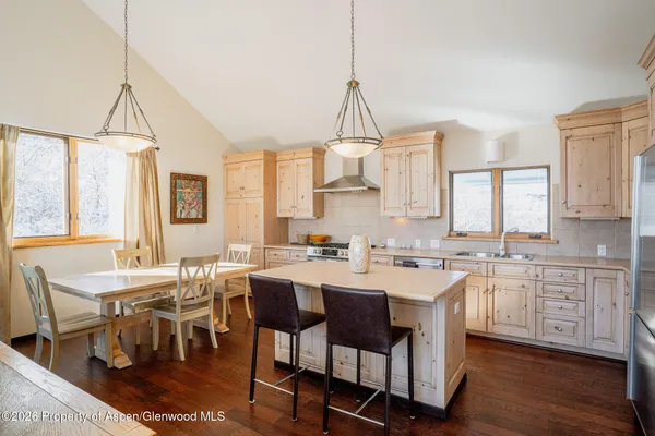 a view of a dining room and livingroom with furniture wooden floor a chandelier