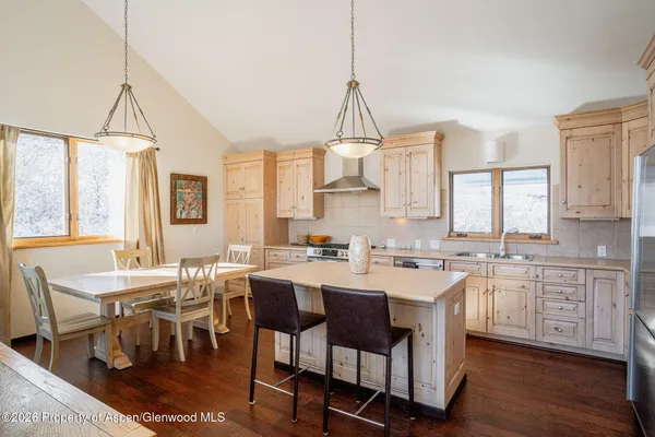 a view of a dining room and livingroom with furniture wooden floor a chandelier
