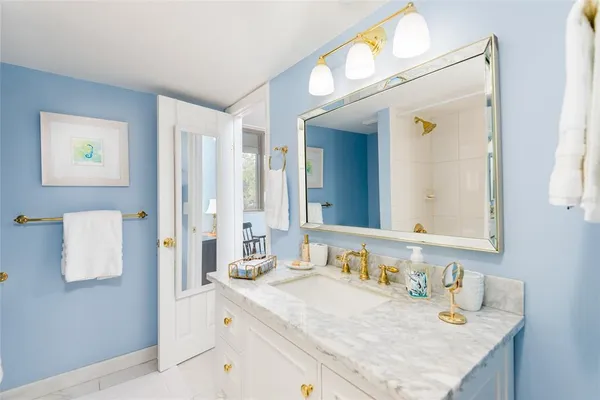 a bathroom with a granite countertop sink and a mirror
