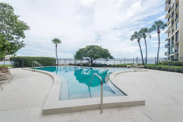 a swimming pool with outdoor seating and plants