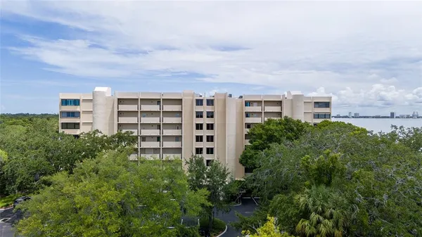 a view of a building next to a big yard and large trees