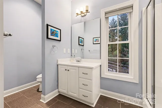 a spacious bathroom with a double vanity sink a mirror and a window