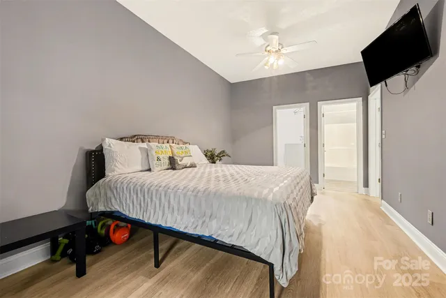 a bedroom with a bed a flat screen tv and a chandelier