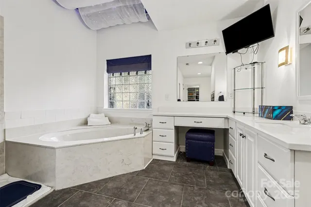 a spacious bathroom with a double vanity sink a mirror and a bathtub